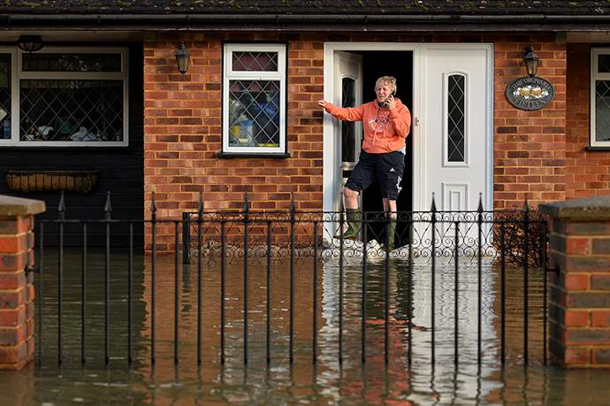 A residents stands at her front door in floodwater in the village of Wraysbury in Berkshire, South East England, on February 10, 2014. (AFP Photo / Ben Stansall)