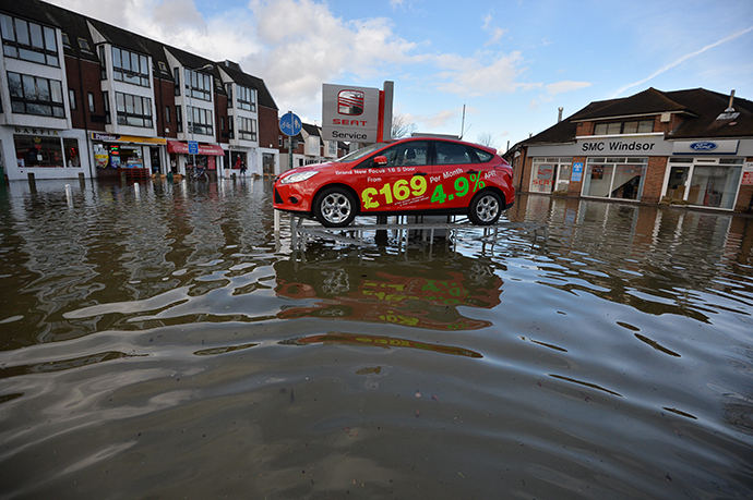 A display car at a car dealership has been left on a ramp above floodwater in Datchet in Berkshire, South East England, on February 10, 2014. (AFP Photo / Ben Stansall)