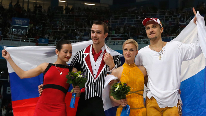 Second-placed Ksenia Stolbova (L) and Fedor Klimov (2nd L) of Russia pose with compatriots, first-placed Tatiana Volosozhar (2nd R) and Maxim Trankov, in front of the Russian national flag, after the figure skating pairs free skating at the Sochi 2014 Winter Olympics, February 12, 2014 (Reuters / Alexander Demianchuk)
