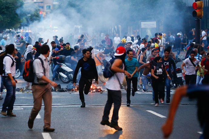 Demonstrators run away from tear gas during a protest in Caracas February 12, 2014.(Reuters / Jorge Silva)
