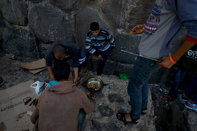 A young Moroccan immigrant looks on during the preperation of the meal mrking the Muslim celebration of Aid ElKebir at Melilla's harbour on October 16, 2013. (AFP Photo / Pierre-Philippe Marcou)