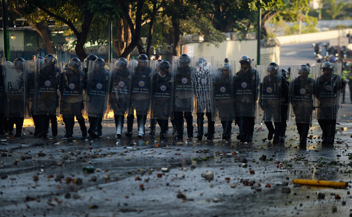 Riot policemen stand in line during clashes with anti-government students holding a protest in Caracas on February 15, 2014. ( AFP Photo / Juan Barreto )