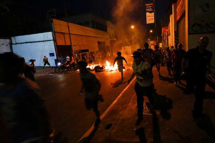 Opposition demonstrators run away from tear gas during a protest against President Nicolas Maduro's government in Caracas February 15, 2014.( Reuters / Jorge Silva)