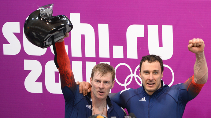 Russia-1 two-man bobsleigh pilot Alexander Zubkov (L) and brakeman Alexey Voevoda celebrate during the Bobsleigh Two-man Flower Ceremony at the Sliding Center Sanki during the Sochi Winter Olympics on February 17, 2014. (AFP Photo / Lionel Bonaventure)