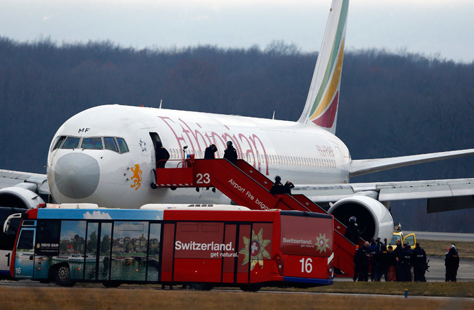 Passengers climb down an airplane ladder with their hands on their heads as police officers stand around hijacked Ethiopian Airlines flight ET 702 at Cointrin airport in Geneva February 17, 2014.(Reuters / Denis Balibouse)