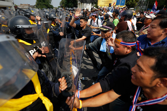 Policemen charge against anti-government protesters at one of their barricades near the Government House in Bangkok February 18, 2014. (Reuters / Damir Sagolj)