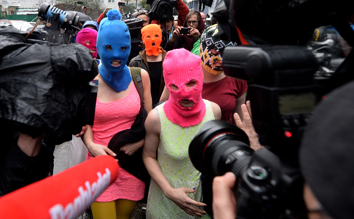 Wearing masks members of Russian punk group Pussy Riot, Nadezhda Tolokonnikova (L) and Maria Alyokhina (R) speak to journalists while leaving the police station of Adler, near Sochi, on February 18, 2014 (AFP Photo / Andrej Isakovic) 