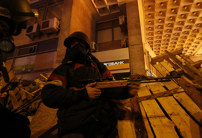 Anti-government rioters take cover behind a temporary barricade during clashes with riot police at Independence Square in Kiev February 18, 2014. (Reuters / Vasily Fedosenko)