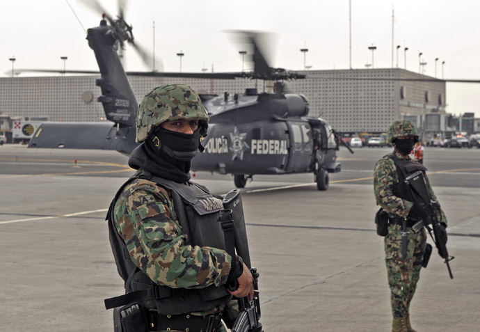 Members of the Mexican Navy stand guard next to a helicopter transporting Mexican drug trafficker Joaquin Guzman Loera aka "el Chapo Guzman", on February 22, 2014 in Mexico City. (AFP Photo / Ronaldo Schemidt) 