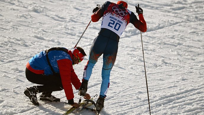 Canadian coach Justin Wadsworth fastens a ski to the foot of Russian athlete Anton Gafarov (RIA Novosti / Konstantin Chalabov)