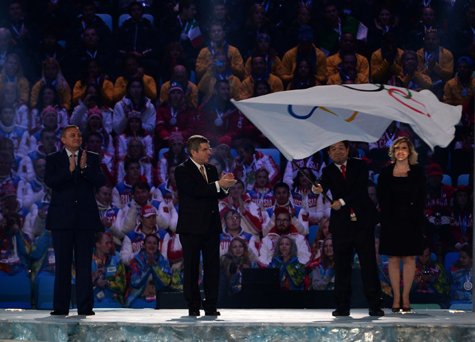 Mayor of Sochi Anatoliy Pakhomov (L) and International Olympic Committee (IOC) President Thomas Bach (C) applaud after handing over the Olympic flag to the Mayor of PyeongChang Lee Seok-rae during the Closing Ceremony of the Sochi Winter Olympics at the Fisht Olympic Stadium on February 23, 2014. (AFP Photo / Peter Parks)