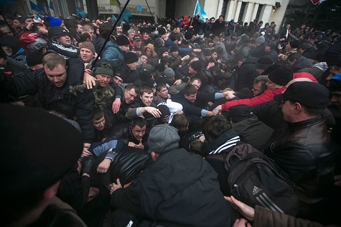 Ukrainian men help pull one another out of a stampede during clashes at rallies held by ethnic Russians and Crimean Tatars near the Crimean parliament building in Simferopol February 26, 2014 (Reuters / Baz Ratner)