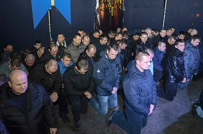 Local riot police kneel as they apologize to Lviv residents for taking part in an operation against anti-government protesters in Kiev but said that they did not beat protesters, during a rally in central Lviv February 24, 2014 (Reuters / Roman Baluk)