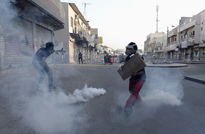 Protesters take cover during clashes that took place during a protest over the death of detainee Jaffar Mohammed Jaffar at a hospital, ahead of his funeral in the village of Daih, west of Manama, February 27, 2014. (Reuters)