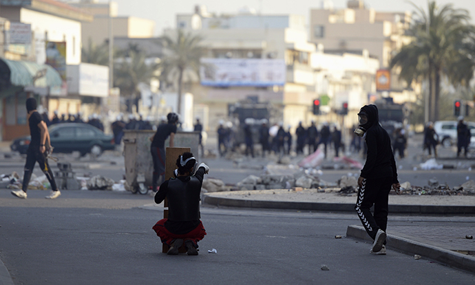 Protesters react towards riot police during clashes taking place during a protest over the death of detainee Jaffar Mohammed Jaffar at a hospital, ahead of his funeral in the village of Daih, west of Manama, February 27, 2014. (Reuters)