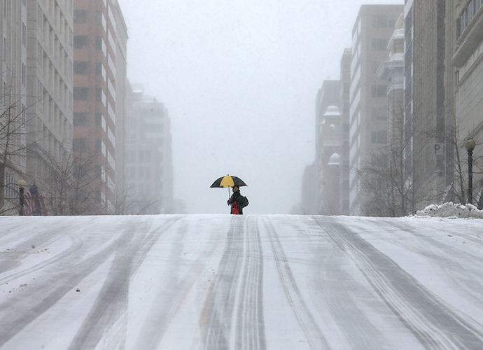 A man walks along a snow covered street, on March 3, 2014 in Washington, DC. (AFP Photo / Mark Wilson)