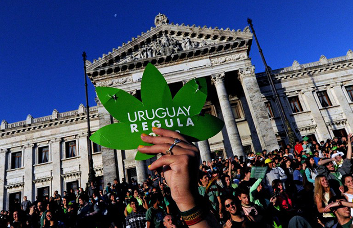 (FILES) People take part in a demo for the legalization of marijuana in front of the Legislative Palace in Montevideo, on December 10, 2013, as the Senate discusses a law on the legalization of marijuana's cultivation and consumption. (AFP Photo / Pablo Porciuncula)