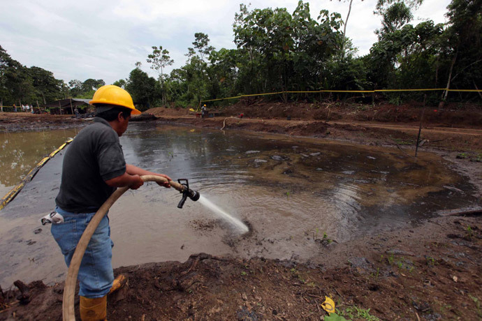 Ecuadorean workers clean up an oil waste pit owned by state petroleum company Petroecuador in Shushufindi, some 410 km (254 mi) east of Quito December 8, 2009.(Reuters / Guillermo Granja)