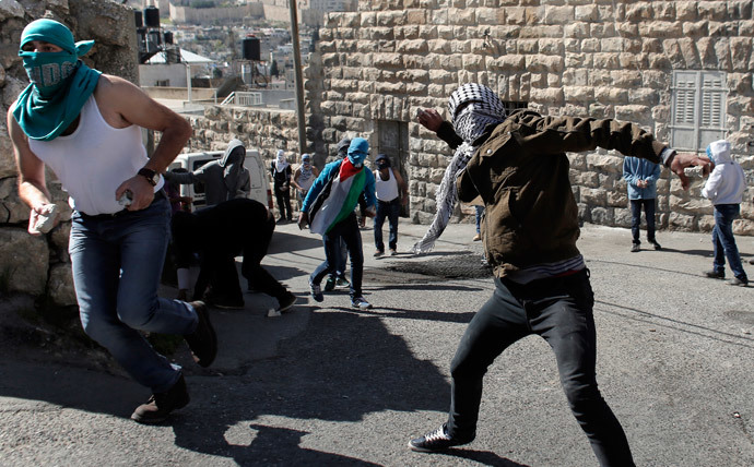 Palestinians throw stones toward Israeli police during clashes in East Jerusalem neighborhood of Ras al-Amud, following noon prayers, on February 28, 2014.(AFP Photo / Ahmad Gharabli)