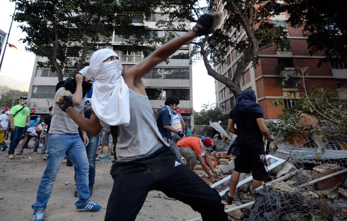 Opposition activists throw stones against National Guard members during a protest against the government of Venezuelan President Nicolas Maduro, in Caracas on March 3, 2014.(AFP Photo /Juan Barreto)