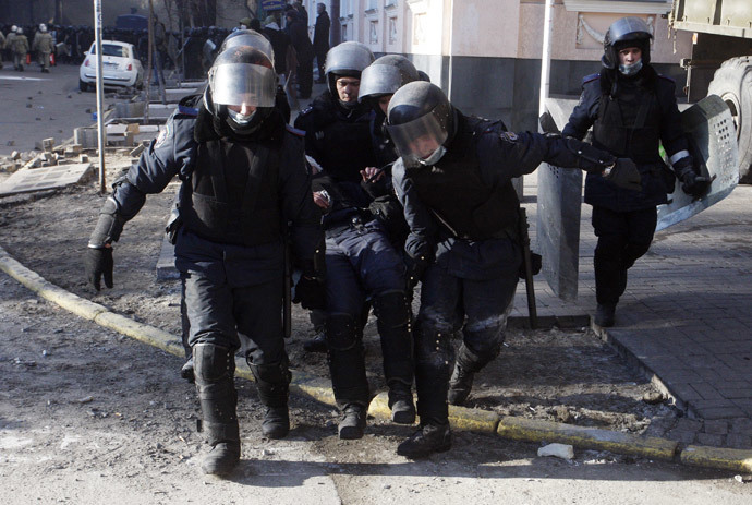 Policemen carry a colleague wounded during clashes with anti-government protesters in Kiev on February 18, 2014. (AFP Photo / Yury Kirnichny) 
