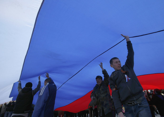 Pro-Russia supporters hold a giant Russian flag during a rally in the Crimean town of Yevpatoria, March 5, 2014. (Reuters)