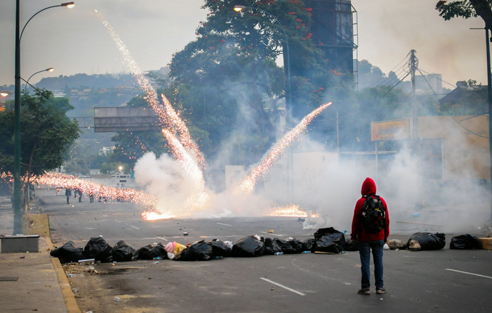 Students clash with the riot police as they protest against the government of Venezuelan President Nicolas Maduro, in Caracas on March 7, 2014 (AFP Photo / Manaure Quintero)
