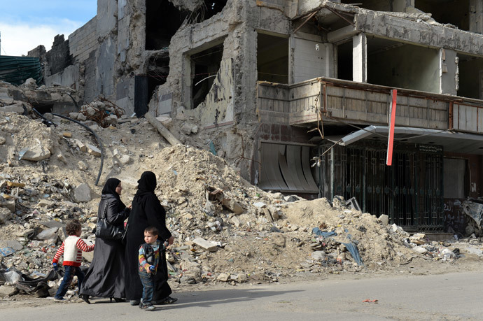 Syrian women walk past the destruction at Dar Al-Shifa hospital in the northern city of Aleppo.(AFP Photo / Miguel Medina)