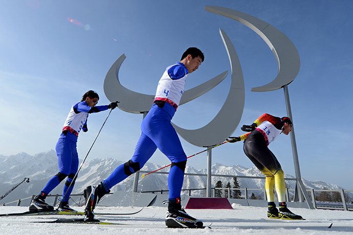 China's Haitao Du (C), China's Dexin Zou (L) and Germany's Tino Uhlig compete during the Men's Cross Country 20 km Classic Standing at XI Paralympic Olympic games in the Rosa Khutor stadium near Sochi on March 10, 2014 (AFP Photo / Kirill Kudryavtsev)