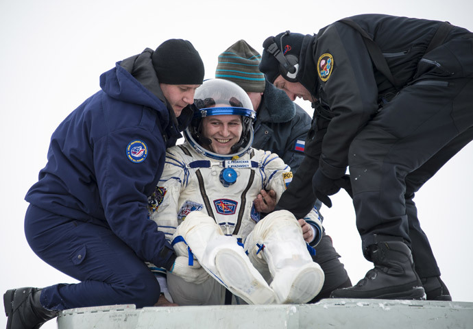 Flight engineer Sergei Ryazansky of Russia is helped out of the Soyuz TMA-10M capsule shortly after the landing in a remote area southeast of the town of Zhezkazgan in central Kazakhstan, March 11, 2014. (Reuters / Bill Ingalls / NASA / Handout via Reuters) 