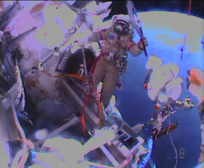 Russian astronaut Oleg Kotov holds an Olympic torch as he begins a spacewalk outside the International Space Station in this still image taken from video courtesy of NASA TV, November 9, 2013. (Reuters/NASA)