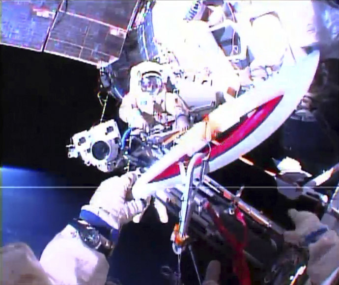 Russian astronaut Oleg Kotov holds an Olympic torch as he takes it on a spacewalk as Russian astronaut Sergei Ryazansky prepares the camera outside the International Space Station in this still image taken from video courtesy of NASA TV, November 9, 2013. (Reuters/NASA)