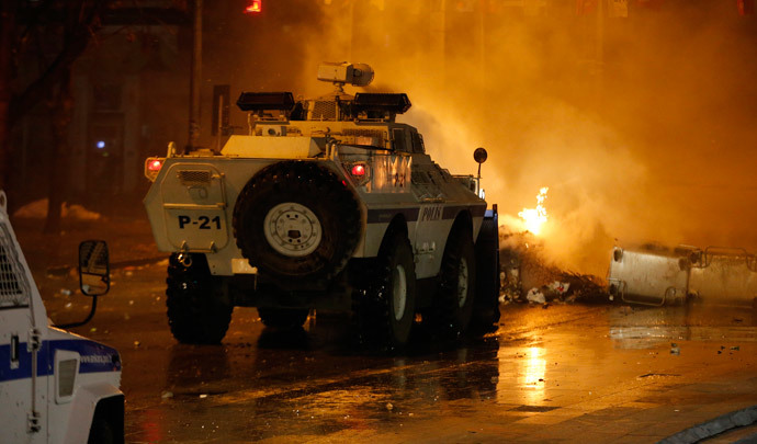 An armoured police vehicle drives through a barricade on fire during a demonstration in Ankara March 12, 2014. (Reuters / Umit Bektas)