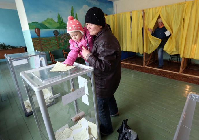 A child holds the ballot of his mother during the referendum on the status of Ukraine's Crimea region at a polling station in Bakhchisaray March 16, 2014.(Reuters / Sergei Karpukhin)