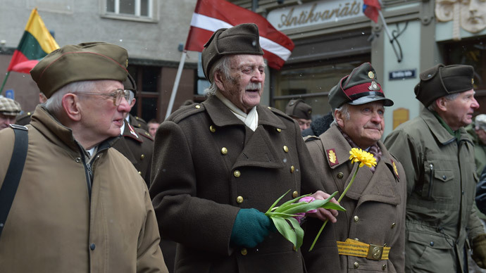 Man dressed in pre-WWII Latvian military uniforms walk along with veterans of the Latvian Legion, a force that was commanded by the German Nazi Waffen SS, and their sympathizers to the Monument of Freedom in Riga, Latvia on March 16, 2014.(AFP Photo / Ilmars Znotinsa)