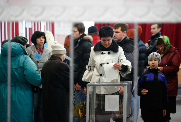 A woman is reflected in a mirror as she casts her ballot during voting in a referendum at a polling station in Simferopol March 16, 2014.(Reuters / Thomas Peter)