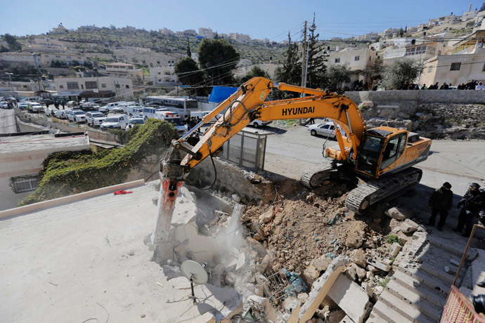 A bulldozer demolishes a house in Jabel Mukaber, a Palestinian village in the suburbs of East Jerusalem February 5, 2014. (Reuters / Ammar Awad)