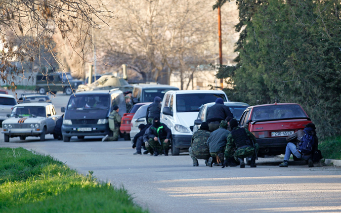 Members of Crimea's self-defense units take cover behind cars outside a military base in the Crimean town of Belbek near Sevastopol March 22, 2014 (Reuters / Vasily Fedosenko)