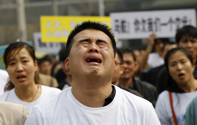 A family member of a passenger on board Malaysia Airlines MH370 cries as he shouts slogans during a protest in front of the Malaysian embassy in Beijing, March 25, 2014. (Reuters/Kim Kyung-Hoon)