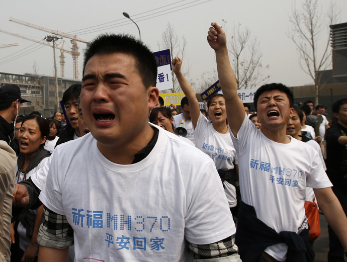Family members of passengers onboard Malaysia Airlines MH370 cry as they shout slogans during a protest in front of the Malaysian embassy in Beijing March 25, 2014. (Reuters/Kim Kyung-Hoon)