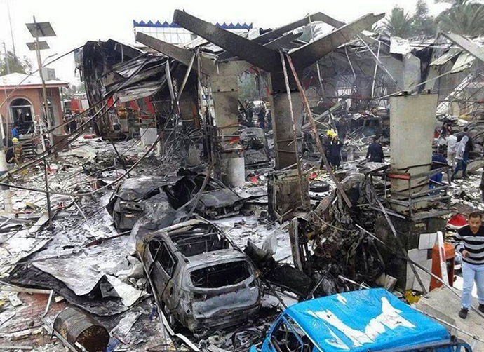 A picture taken on March 9, 2014 shows burnt out vehicles at the site of a suicide bombing that killed at least 21 people at a checkpoint near Baghdad. (AFP Photo)