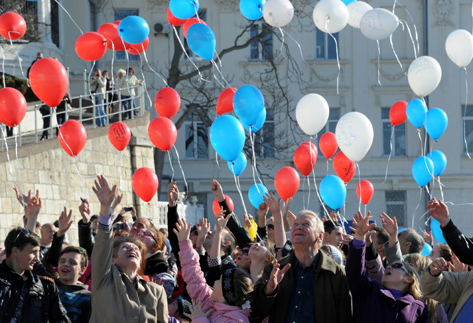 People launch balloons painted in the colors of the Russian flag during a flash mob in the Crimean city of Sevastopol on March 23, 2014. (AFP Photo / Viktor Drachev)