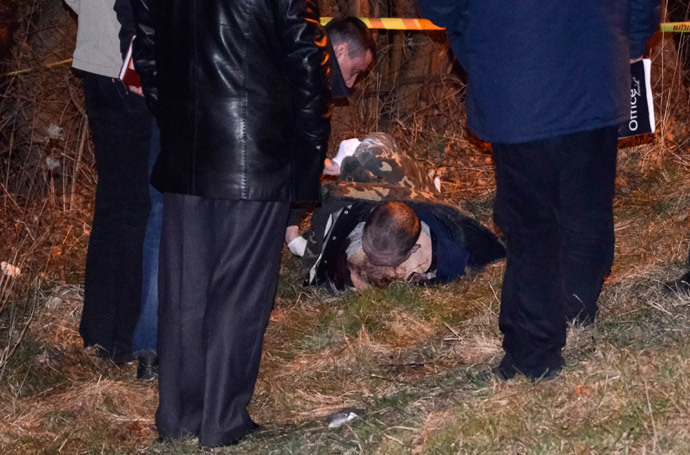 Police look at the body of Oleksander Muzychko, also known as Sashko Bily, lying on the ground near Rivne March 25, 2014. (Reuters / Olexandr Kursik)