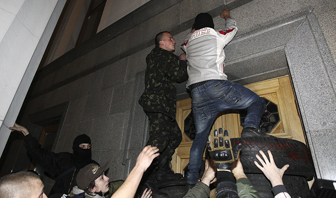 Men climb onto the parliament building as activists of the Right Sector movement and their supporters gather to demand the immediate resignation of Internal Affairs Minister Arsen Avakov, in Kiev March 27, 2014. (Reuters / Valentyn Ogirenko)