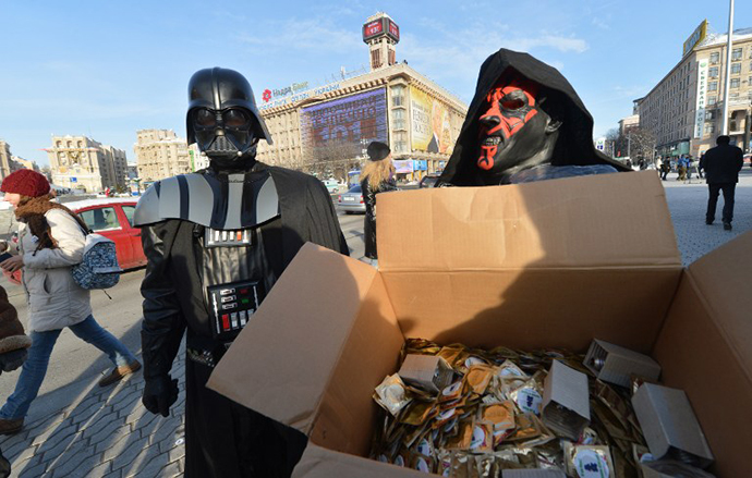 A leader of the Ukrainian Internet Party, wearing a Darth Vader outfit from the Star Wars saga, and an activist distribute goods on December 20, 2012 on Independence Square in Kiev. (AFP Photo / Sergey Supinsy)