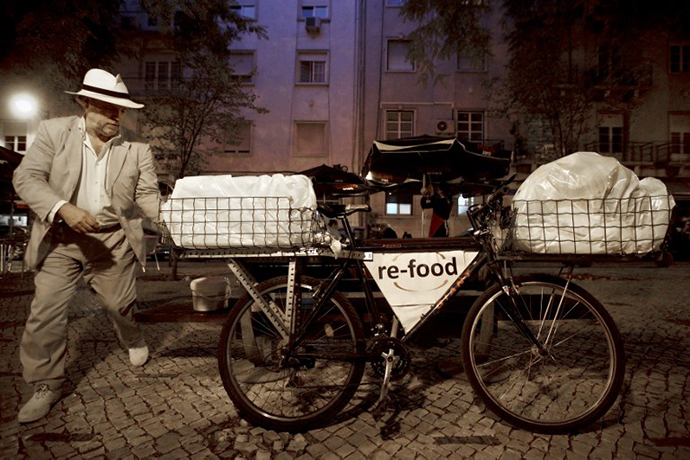 Hunter Halder walks toward his bicycle loaded with food that he collected in restaurants in Lisbon. (AFP Photo / Patricia De Melo Moreira)