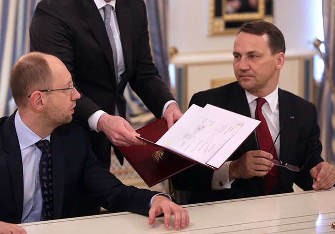 Poland's Foreign Minister Radoslaw Sikorski (R) and Ukraine's opposition leader Arseny Yatsenyuk (L) prepare to sign an EU-mediated peace deal with President Viktor Yanukovich, aiming to end a violent standoff that has left dozens dead and opening the way for a early presidential election this year, at the presidential headquarters in Kiev February 21, 2014. (Reuters / Konstantin Chernichkin)