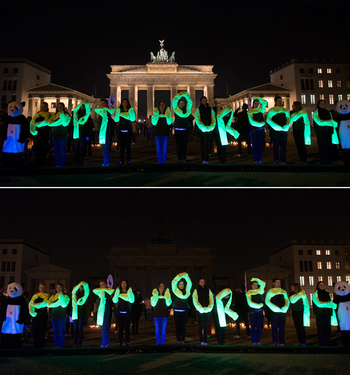 The combo picture shows activists of World Wide Fund (WWF) posing in front of the Brandenburg Gate during the Earth Hour environmental campaign in March 29, 2014 in Berlin. (AFP Photo / Johannes Eisele)