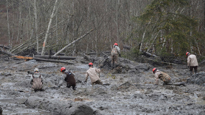 Washington National Guard rescue workers make their way through the mud and wreckage left behind by Saturday's mudslide as they look for signs of missing persons, in Oso, Washington March 27, 2014.(Reuters / Matthew Sissel)