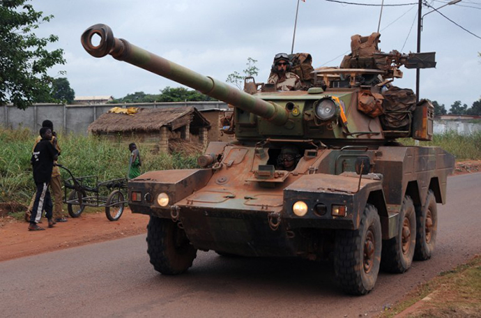 Young boys looks on as part of a convoy of French troops, including around fifty armored tanks and trucks, arrives in Bangui on February 27, 2014 from Chad to reinforce the French troops of operation Sangaris. (AFP Photo / Sia Kambou)